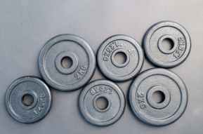 six assorted weight plates on top of gray surface