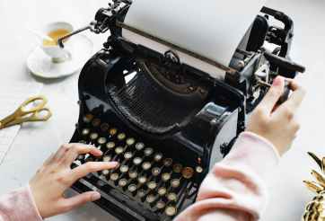 woman uses black typewriter